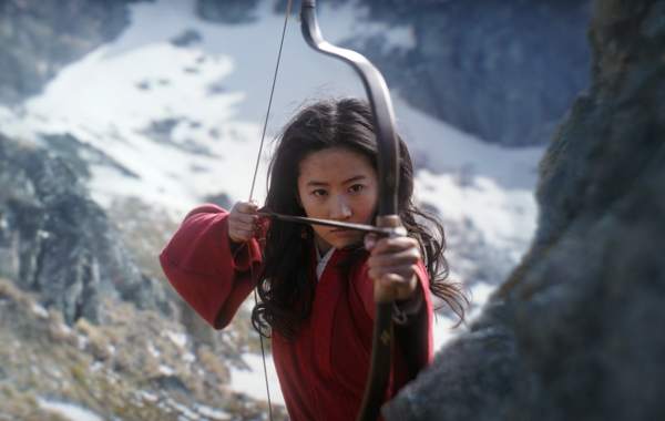 woman in a red robe aims a bow and arrow